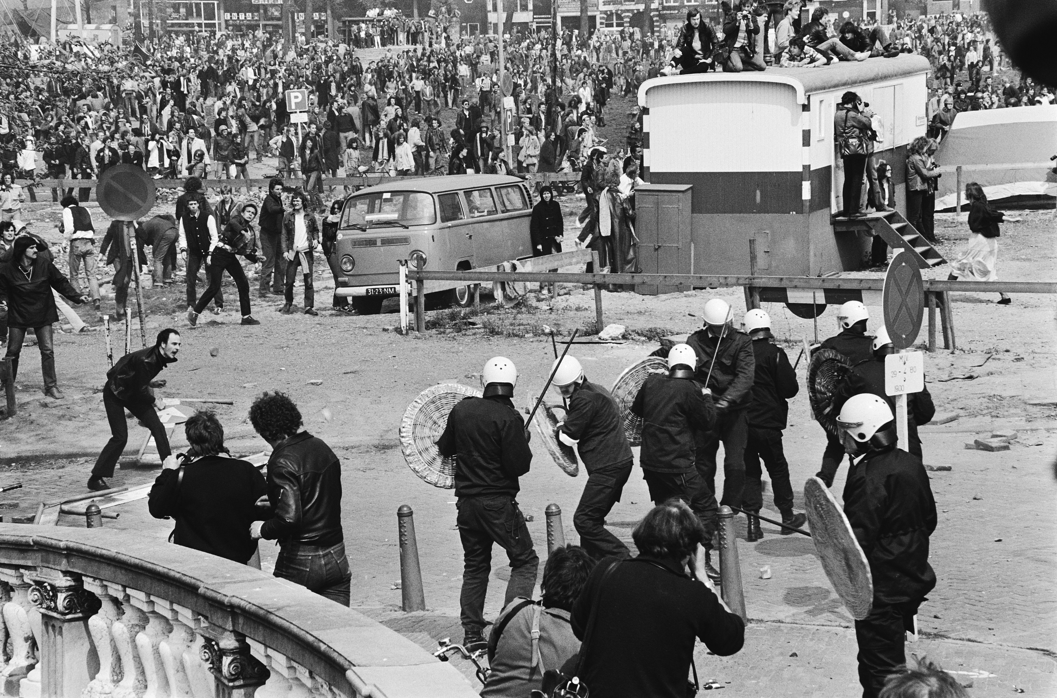 Schauplatz im Roman "De slag om de Blauwbrug" von A.F.Th. van der Heijden: Die Blauwbrug in Amsterdam, wo am Tag der Inthronisation von Königin Beatrix (30. April 1980) Unruhen zwischen den „Krakers“ und der Polizei stattgefunden haben.